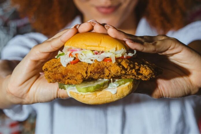 Close-up of Fuku’s signature crispy fried chicken sandwich with pickles and Fuku mayo on a toasted potato roll.