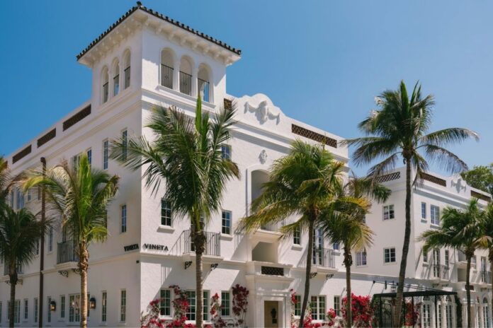 The Vineta Hotel in Palm Beach featuring its restored pink Mediterranean Revival exterior and luxury courtyard entrance.