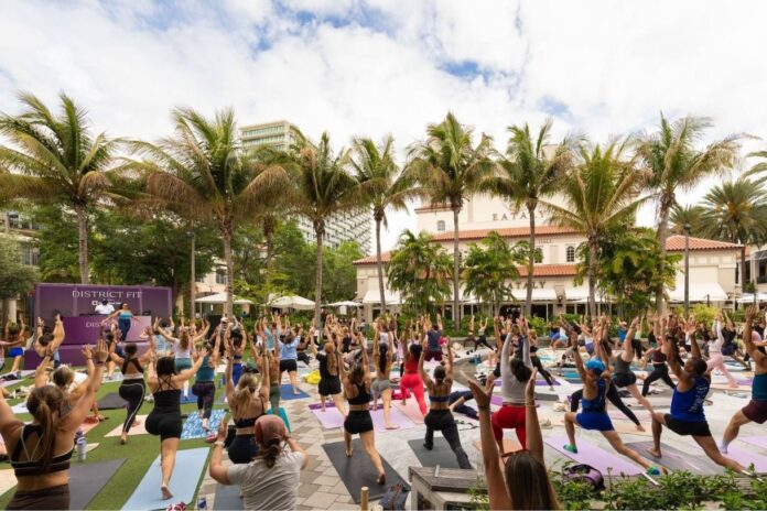 Crowds gather at District Fit wellness festival at CityPlace in West Palm Beach featuring fitness classes, DJs, and wellness activations.