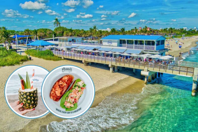 A tropical cocktail served inside a pineapple sits against the backdrop of Lake Worth Beach, representing Benny’s on the Beach, whose lease has been extended through 2043.