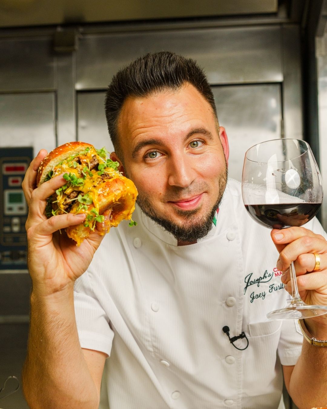 Owner Joseph J. Acierno showing off a sandwich and a glass of wine