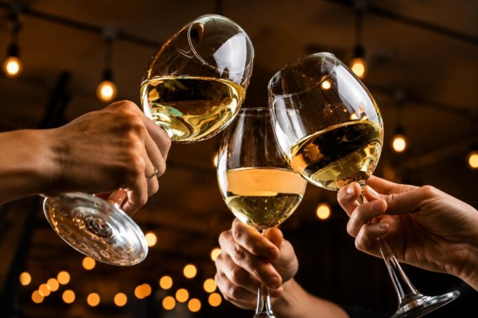 Wine glasses raised in a toast for the 2026 Palm Beach Food & Wine Festival.