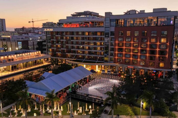 The Ben hotel overlooking its illuminated outdoor holiday ice skating rink at sunset in downtown West Palm Beach.